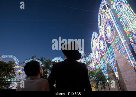 Gerusalemme, Israele. Il 10 giugno 2014. Ortodosso Ebrei religiosi ammirate una luce che mostra l'installazione presso la Porta di Jaffa città vecchia dduring Gerusalemme il Festival della luce in Israele che si svolge annualmente intorno alla città vecchia con effetti speciali di illuminazione siti storici e mostra il lavoro di importanti artisti internazionali. Foto Stock