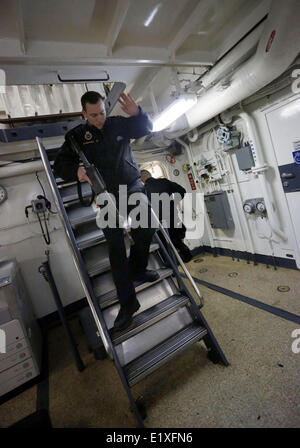 Vancouver, Canada. Decimo Giugno, 2014. Armato di un membro di equipaggio cammina giù dal ponte della Marina canadese HMCS nave Winnipeg vicino alla costa di Vancouver, Canada, 10 giugno 2014. Media uniti con i membri della comunità e le parti interessate la vela a bordo marina canadese HMCS nave Winnipeg per un tour di un giorno di manifestazione, attraverso il tour guidato di emergenza e nave dimostrazioni di manovra, la marina provare a lasciare che il pubblico in generale per saperne di più sulla vita e i doveri come militare canadese. Credito: Liang Sen/Xinhua/Alamy Live News Foto Stock