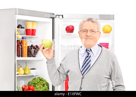 Senior uomo prendendo apple fuori dal frigorifero Foto Stock