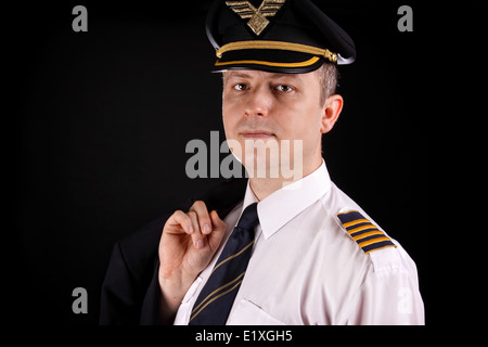 Ritratto di un giovane capitano in uniforme su uno sfondo nero Foto Stock