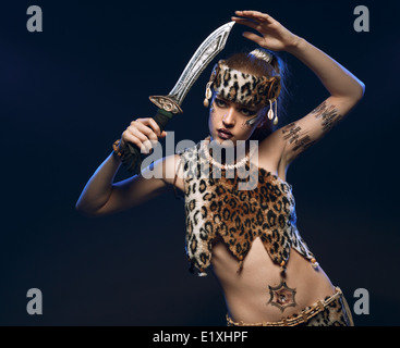 Bella combattente donna con una spada nelle sue mani. Studio fotografico. Foto Stock