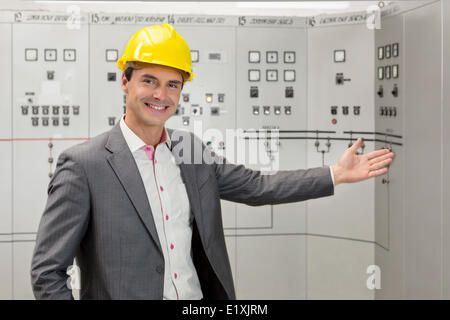 Ritratto di giovane maschio manager gesticolando in sala di controllo Foto Stock