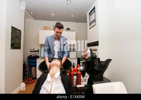 Parrucchiere maschio femmina di lavaggio del cliente capelli nel salone di bellezza Foto Stock