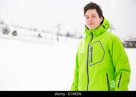 Ritratto di giovane uomo indossando giacca con cappuccio in snow Foto Stock