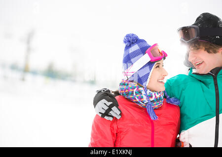 Amorevole coppia giovane guardando ogni altro nella neve Foto Stock