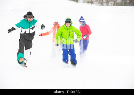 Lunghezza completa di giovani amici divertendosi in neve Foto Stock