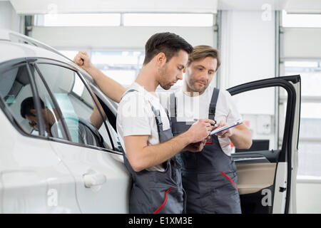 Meccanica automobilistica checklist di controllo permanente, mentre in auto in officina Foto Stock