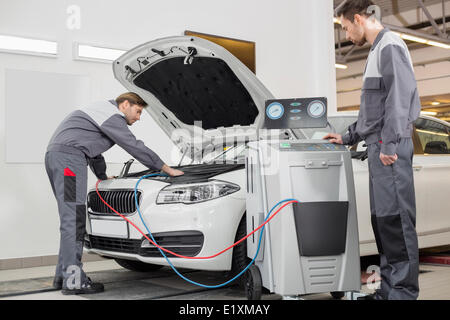 Maschio meccanica automobilistica Esame auto nel negozio di riparazione Foto Stock