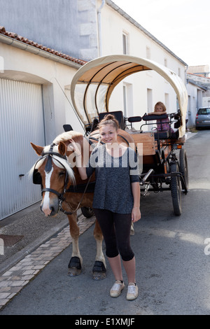 La bella ragazza con una carrozza trainata da cavalli (la Ronde - Francia). La belle jeune fille à l'attelage hippomobile (Francia). Foto Stock