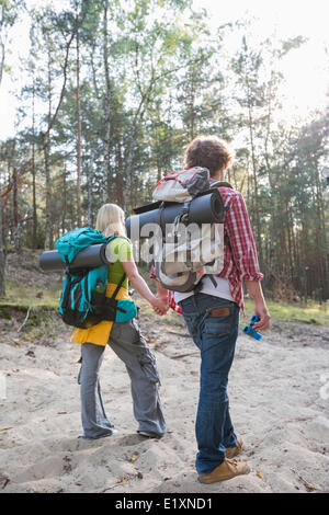 Vista posteriore di escursionismo coppia con zaini passeggiate in foresta Foto Stock