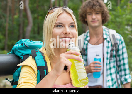 Escursionismo coppia con bevande energetiche in foresta Foto Stock