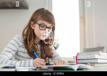 Ragazza adolescente facendo i compiti sul tavolo Foto Stock