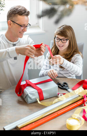 Felice padre e figlia di Natale di incarto presente a casa Foto Stock