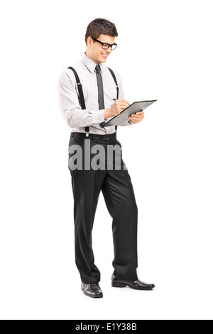 A piena lunghezza Ritratto di un uomo elegante scrittura su un blocco appunti Foto Stock