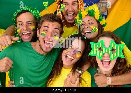 Gruppo felice del brasiliano sport soccer fans stupiti celebrando la vittoria insieme. Foto Stock