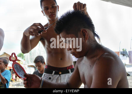 Giugno 11, 2014 - Tacloban, Filippine - Tacloban, Filippine - Marco Largo, 23 ha un taglio di capelli presi in Tacloban City il 11 giugno 2014. Il 8 novembre 2013, Haiyan, uno dei più potenti typhoon mai a colpire paese devastato Eastern Visayas lasciando migliaia di morti e di sfollati. Secondo le stime del governo 16 milioni di persone sono state colpite dal tifone, con 6.300 riportati morti e migliaia di più manca. Alloggiamento e mezzi di sostentamento sono tra le gravi sfide nel processo di riabilitazione in Haiyan-aree colpite sette mesi dopo il disastro. (Credito Immagine: © Mark Cristino/NurPhoto/ZUMAPRESS.c Foto Stock