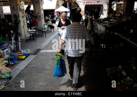 Un uomo che porta una borsa da shopping nel mercato Kapani a Salonicco, Grecia Foto Stock