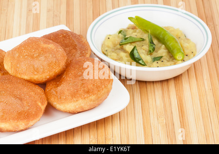 Deliziosi fritti poori (puri) servito con patate speziate cipolla curry (saagu). Foto Stock