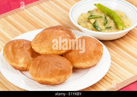Deliziosi fritti poori (puri) servito con patate speziate cipolla curry (saagu). Foto Stock