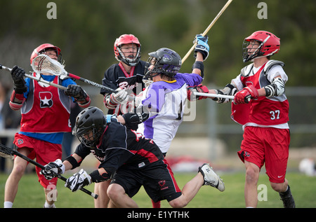 Alta scuola ragazzi indossare i caschi e di gareggiare in una gamma lacrosse corrispondono a Austin, Texas. Foto Stock