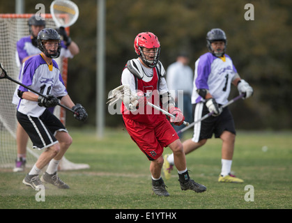 Alta scuola ragazzi indossare i caschi e di gareggiare in una gamma lacrosse corrispondono a Austin, Texas. Foto Stock