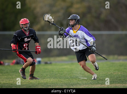 Alta scuola ragazzi indossare i caschi e di gareggiare in una gamma lacrosse corrispondono a Austin, Texas. Foto Stock