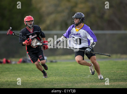 Alta scuola ragazzi indossare i caschi e di gareggiare in una gamma lacrosse corrispondono a Austin, Texas. Foto Stock