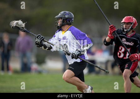 Alta scuola ragazzi indossare i caschi e di gareggiare in una gamma lacrosse corrispondono a Austin, Texas. Foto Stock