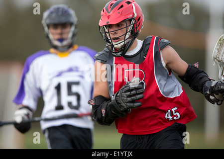 Alta scuola ragazzi indossare i caschi e di gareggiare in una gamma lacrosse corrispondono a Austin, Texas. Foto Stock