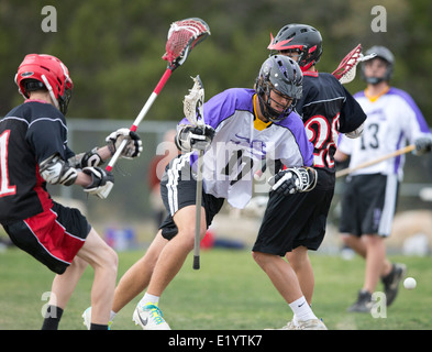 Alta scuola ragazzi indossare i caschi e di gareggiare in una gamma lacrosse corrispondono a Austin, Texas. Foto Stock