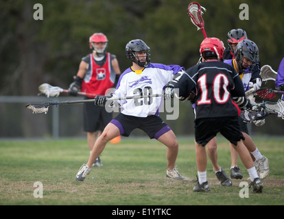 Alta scuola ragazzi indossare i caschi e di gareggiare in una gamma lacrosse corrispondono a Austin, Texas. Foto Stock