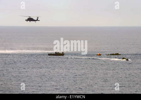 US Navy marinai rifugiati di salvataggio da sei piccole imbarcazioni per il missile guidato fregata USS Elrod dopo la ricezione di una chiamata per assistenza italiana da pattugliamento marittimo Giugno 6, 2014 nel mar Mediterraneo. Più di 300 rifugiati provenienti da Africa sono stati liberati e trasferiti al governo di Malta dopo essere stato dato cibo e acqua. Foto Stock