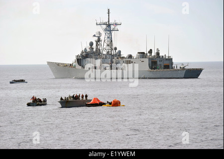 US Navy marinai rifugiati di salvataggio da sei piccole imbarcazioni per il missile guidato fregata USS Elrod dopo la ricezione di una chiamata per assistenza italiana da pattugliamento marittimo Giugno 6, 2014 nel mar Mediterraneo. Più di 300 rifugiati provenienti da Africa sono stati liberati e trasferiti al governo di Malta dopo essere stato dato cibo e acqua. Foto Stock