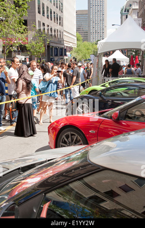 I turisti guardano costose supercars sul Peel Street a Montreal durante il Formula One Grand Prix Weekend Foto Stock