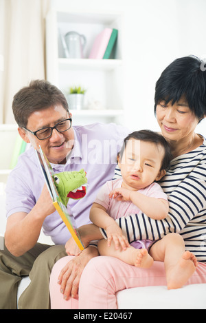 Nonni cinese alla lettura della storia prenota a piangere grand figlia Foto Stock