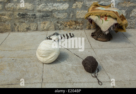 Il Nepal Yak filati di lana e uno sgabello tradizionale seduta contro la parete di uno sherpa Tea House nel villaggio di Thamo, Solukhumbu Foto Stock