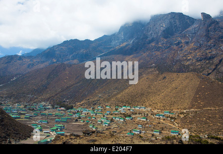 Il Nepal il villaggio di Khumjung con il cloud e rabboccato Himalaya ripida salita al di sopra di esso. remote, Mt Everest, Himalaya Foto Stock