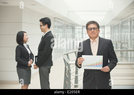 Senior asian business ceo che mostra rapporto positivo con il team sullo sfondo Foto Stock