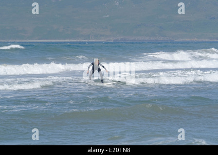 Una giovane donna che naviga a riva di Porth Neigwl Foto Stock