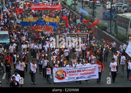 Manila, Filippine. 12 Giugno, 2014. Gli attivisti tenere le torce e cartelloni durante una manifestazione di protesta contro la priorità allo sviluppo del Fondo di assistenza truffa o di maiale canna truffa di Manila nelle Filippine il 12 giugno 2014. Gli attivisti chiamata per la detenzione di tutti i politici coinvolti nell'abuso dei dieci miliardi di pesos fondo di governo. Credito: Rouelle Umali/Xinhua/Alamy Live News Foto Stock