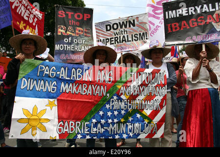 Manila, Filippine. 12 Giugno, 2014. Manifestanti holding manifesti contro la difesa avanzata Accordo di cooperazione a Kalaw, Manila. Diverse centinaia di manifestanti hanno tenuto diverse manifestazioni di protesta in tutto Metro Manila la marcatura del Filippine " 116Giorno di Indipendenza. Diversi gruppi chiamati per la responsabilità e la trasparenza in merito agli scandali di corruzione di alti funzionari del governo. I manifestanti hanno anche chiesto la cacciata del Presidente Aquino per il suo presunto incompetency nel governare la sua amministrazione. Credito: PACIFIC PRESS/Alamy Live News Foto Stock