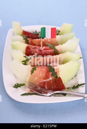 Mature fette di melone con prosciutto, parmigiano, bandiera dell'Italia, verticale Foto Stock