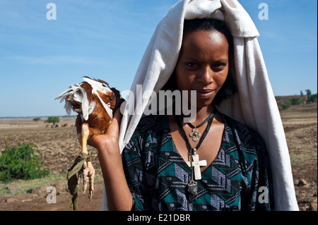 Ragazza appartenente al gruppo Amhara andare al mercato a vendere una gallina. Lei è un cristiano ortodosso (Etiopia) Foto Stock