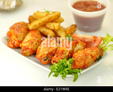 Hot ali di pollo con patate fritte Foto Stock