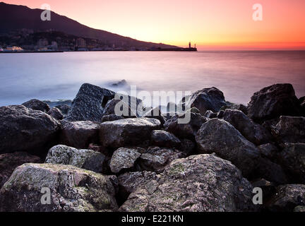 Tramonto sulla spiaggia rocciosa Foto Stock