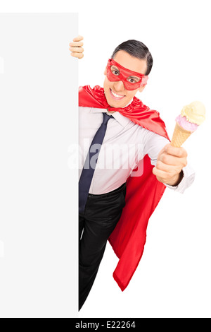 Il supereroe tenendo un gelato dietro un pannello vuoto Foto Stock