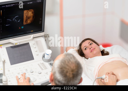 Medico fare 3d ultrasuoni sul ventre della donna incinta in clinica Foto Stock