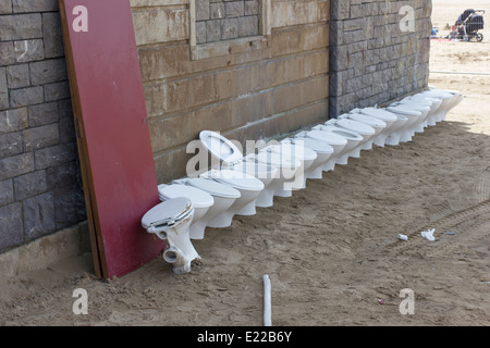Una fila di toilette rimosso da un wc pubblico sulla spiaggia di Weston-super-Mare, England, Regno Unito Foto Stock