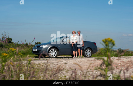 Coppia di anziani con un 2007 Renault Megane coupé cabriolet 150DCI autovettura convertibile Foto Stock