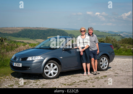 Coppia di anziani con un 2007 Renault Megane coupé cabriolet 150DCI autovettura convertibile Foto Stock